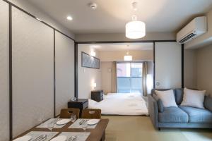 a hotel room with a bed and a couch at 心斎橋-道頓堀の宿 ー南海難波徒歩10分以内 in Osaka