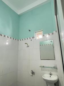 a white bathroom with a mirror and a sink at Homestay Xuân Mai in Quang Ngai