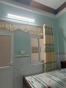 a bedroom with a bed and a mirror and a window at Homestay Xuân Mai in Quang Ngai