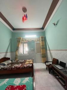 a bedroom with a bed and a table and a desk at Homestay Xuân Mai in Quang Ngai
