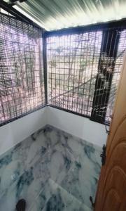 a room with two windows and a marble floor at Areca Adventures Family Cottage in Kushālnagar