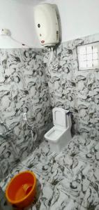 a bathroom with a black and white wallpaper with a toilet at Areca Adventures Family Cottage in Kushālnagar
