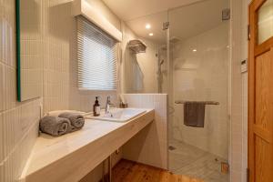 a bathroom with a sink and a shower at Hotel Haus St Anton in Nozawa Onsen