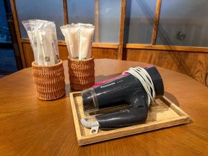 uma garrafa num tabuleiro de madeira sobre uma mesa em SUMITSUGU HOUSE East em Kumamoto