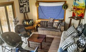 ein Wohnzimmer mit einem Sofa und einem Tisch in der Unterkunft Bamboo Room in Ponta do Ouro