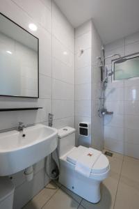 een witte badkamer met een wastafel en een toilet bij Bear Paw Retreat Cityview Apartment Amber Cove in Melaka