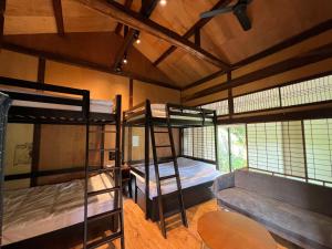 a room with two bunk beds and a couch at SUMITSUGU HOUSE East in Kumamoto