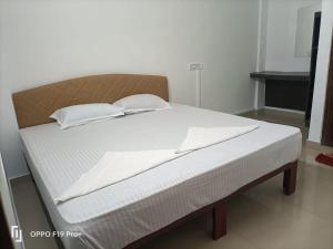 Dona Residency في نيدومباسيري: سرير عليه وسادتين في غرفة