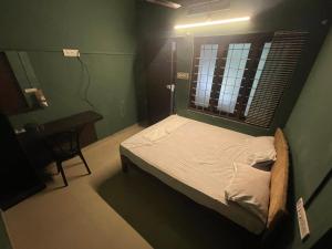 Dona Residency في نيدومباسيري: سرير صغير في غرفة مع نافذة