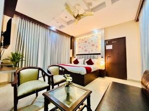 une chambre d'hôtel avec un lit, une table et des chaises dans l'établissement Hotel Rama, Top Rated and Most Awarded Property In Haridwar, à Haridwar