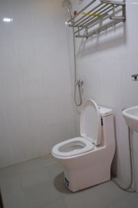 a bathroom with a white toilet and a sink at Jungle House Kep 2 in Phumĭ Ŏng Char