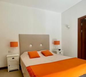 a bedroom with a bed with two orange pillows at Villa Balinaise avec piscine in Rivière Noire