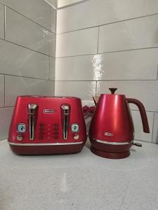 a red toaster and a red toaster on a counter at The Golf Getaway in Myrtleford