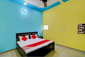 a bedroom with a bed in a room with green walls at OYO Flagship Midtown Guesthouse in Jhājhar