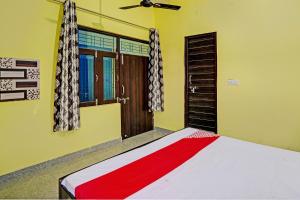 a bedroom with a bed and a ceiling fan at OYO Flagship Midtown Guesthouse in Jhājhar