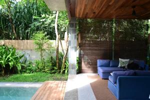 een patio met blauwe banken naast een zwembad bij Pandan Villas, El Nido in El Nido