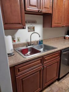 a kitchen with a stainless steel sink and wooden cabinets at Lovely 2 Bedroom Condo with Views of the Mountains in Gatlinburg