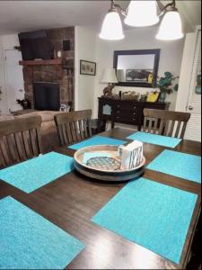 a dining room table with blue mats on it at Lovely 2 Bedroom Condo with Views of the Mountains in Gatlinburg