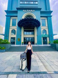 uma mulher em pé em frente a um edifício com bagagem em Altara Apartment Quy Nhơn - 2Bed Room - Seaview em Quy Nhon