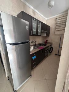 a kitchen with a stainless steel refrigerator and a sink at Studio Relax à Malabata Tanger in Tangier