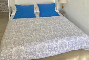 um quarto com uma cama com almofadas azuis em Monte Carlo border sea view 10 min to Casinò em Beausoleil