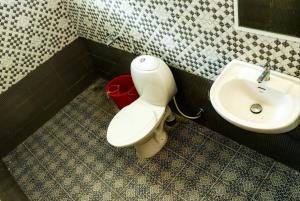 a bathroom with a toilet and a sink at Nest Villa in Athirappilly