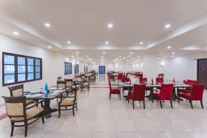 a dining room with tables and red chairs at Shree Vallabh Vilas Lords Plaza in Eklingji