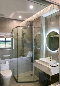 a bathroom with a shower and a toilet and a sink at Milash Boutique Hotel in Ha Long