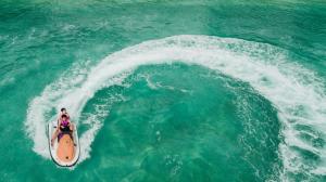 eine Person auf einem Surfbrett in einer Welle im Ozean in der Unterkunft Durhan White Beach Resort in Tabuelan