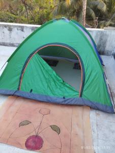 une tente verte installée au-dessus d'un parquet dans l'établissement Hotel Grand Murud janjira, à Murud