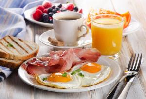un plato de desayuno con huevos y tostadas y una taza de café en THE CLOVER Home Stay, en Srinagar