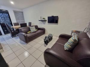 uma sala de estar com dois sofás e uma televisão em Casa con alberca a 15min poliforum y centro max Brisas em León