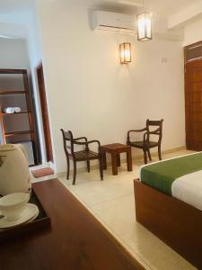 - une chambre avec un lit, deux chaises et une table dans l'établissement Bienvenido Cozy Marker, à Matara