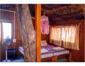 een slaapkamer met een stapelbed en een boom bij Tanshikar Spice Farm, Sanguem in Vichondrem