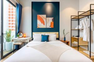 a bedroom with a large white bed with blue accents at Hoi An Pinus Boutique in Tân Thành (1)