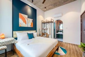 um quarto com uma grande cama branca e uma parede azul em Hoi An Pinus Boutique em Tân Thành (1)