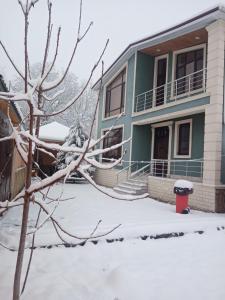 uma casa azul com neve no chão em Green villa em Gabala