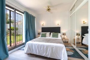 a bedroom with a bed and a large window at Family villa with garden next to the beach in Mijas Costa