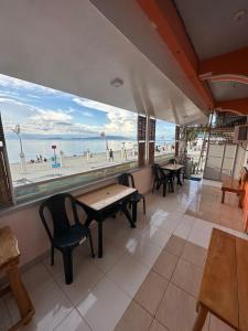 restauracja ze stołami i widokiem na plażę w obiekcie Buena Lynne's Resort w mieście Balatero