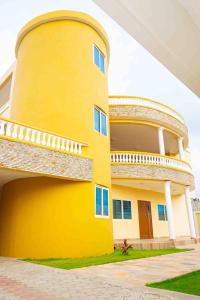 a yellow building with a balcony on the side of it at House 5 Mins From the Beach, 15 Mins From the Airport in Cotonou
