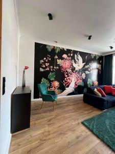 a living room with a couch and a painting on the wall at Kolejowa 4 Boutique Apartment in Nowa Ruda