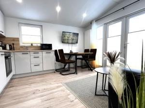 eine Küche und ein Wohnzimmer mit Tisch und Stühlen in der Unterkunft Ostseecamp Ostseewind in Scharbeutz