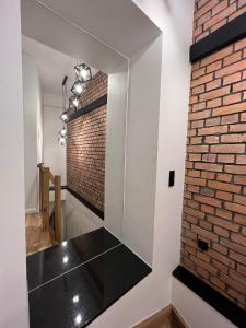 a bathroom with a brick wall and a black counter at Kolejowa 4 Boutique Apartment in Nowa Ruda