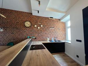 a room with a brick wall and a clock on the wall at Kolejowa 4 Boutique Apartment in Nowa Ruda