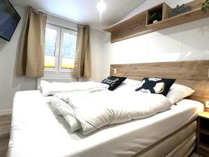 ein Schlafzimmer mit einem großen Bett mit weißen Laken und Kissen in der Unterkunft Ostseecamp Ostseewind in Scharbeutz