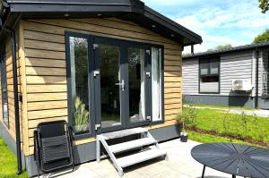 Cabaña pequeña con silla y mesa en Ostseecamp Ferienhaus "Lüttche Hus" en Scharbeutz