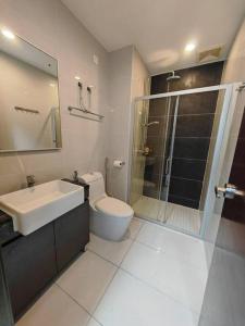 La salle de bains est pourvue de toilettes, d'un lavabo et d'une douche. dans l'établissement Sweet Home 暖居 Danga Bay CountryGarden, à Johor Bahru