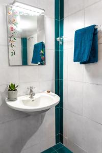 a bathroom with a sink and a mirror and blue towels at BEST SERVICED APARTMENT IN COCHIN,MARINE DRIVE in Cochin