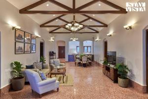 a large living room with a chandelier and a living room at StayVista's Villa Terra - Valley & Lake-View Villa with Spacious Lawn & Indoor Activities in Panchgani