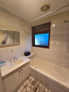 a bathroom with a sink and a bath tub at The Golf Getaway in Myrtleford +15 photos